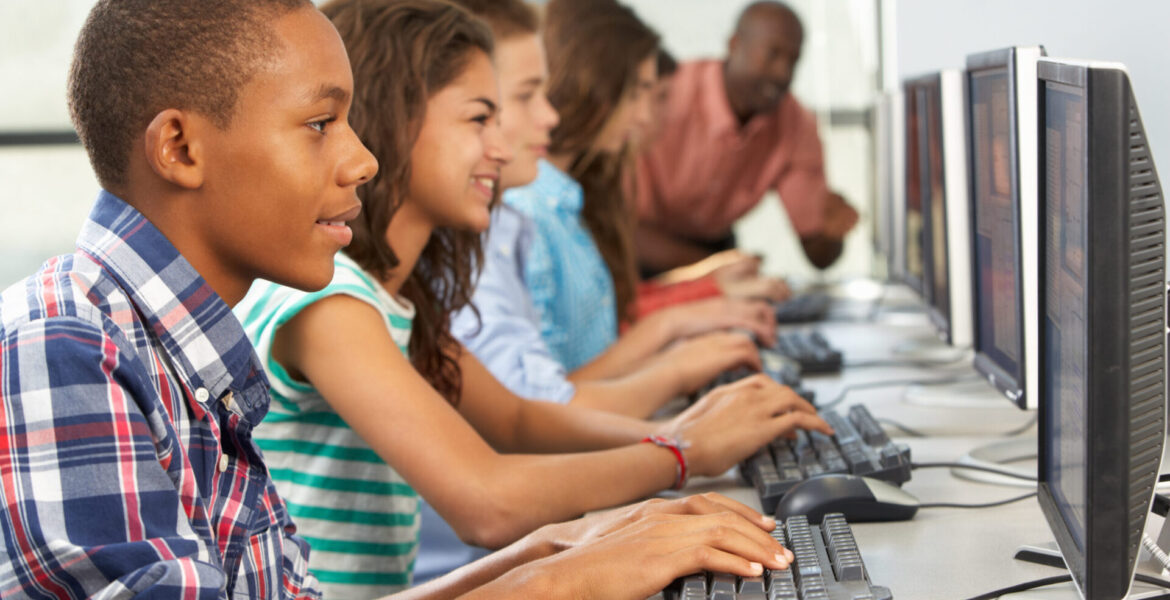 Group Of Students Working At Computers In Classroom