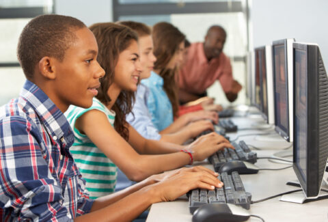 Group Of Students Working At Computers In Classroom