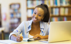 african college student studying a book in library