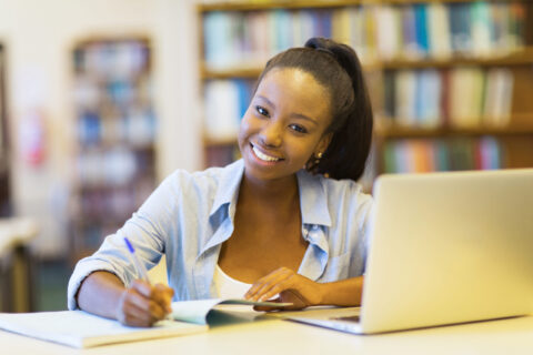 african college student studying a book in library